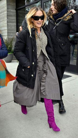 Sarah Jessica Parker wearing purple knee high boots, ruffled maxi skirt and cosy cardigan