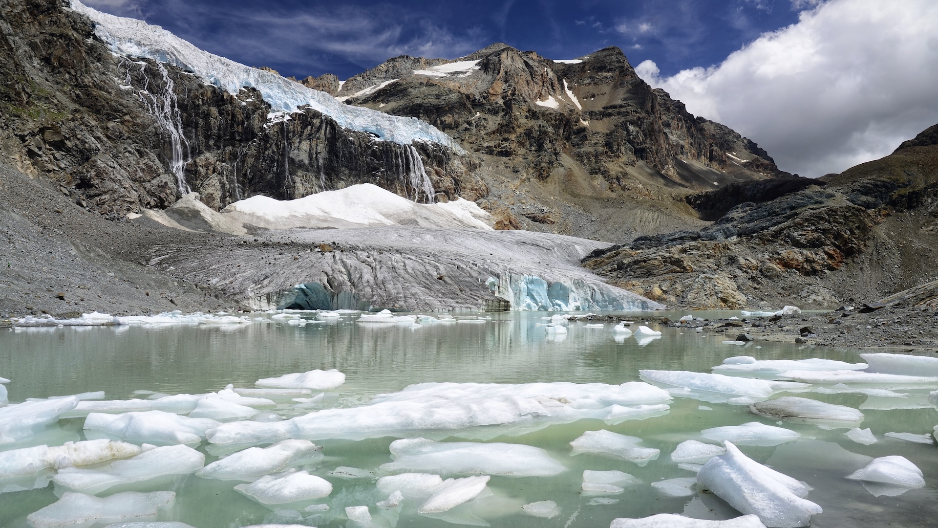 A photo showing a glacier breaking into pieces in an alpine lake