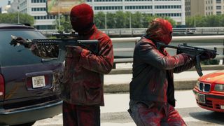 Two masked gunmen stand back to back in Triple 9