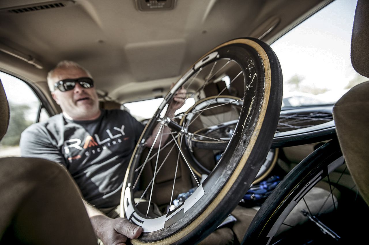 Tim Sparks team Mechanic brandishes Brad's wrecked wheel. 'At least we'll have lighter luggage for the journey home!'
