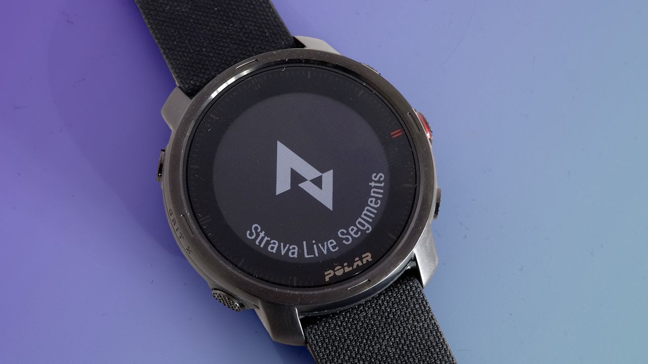 The Polar Grit X on a purple background displaying the Strava Live segments screen.