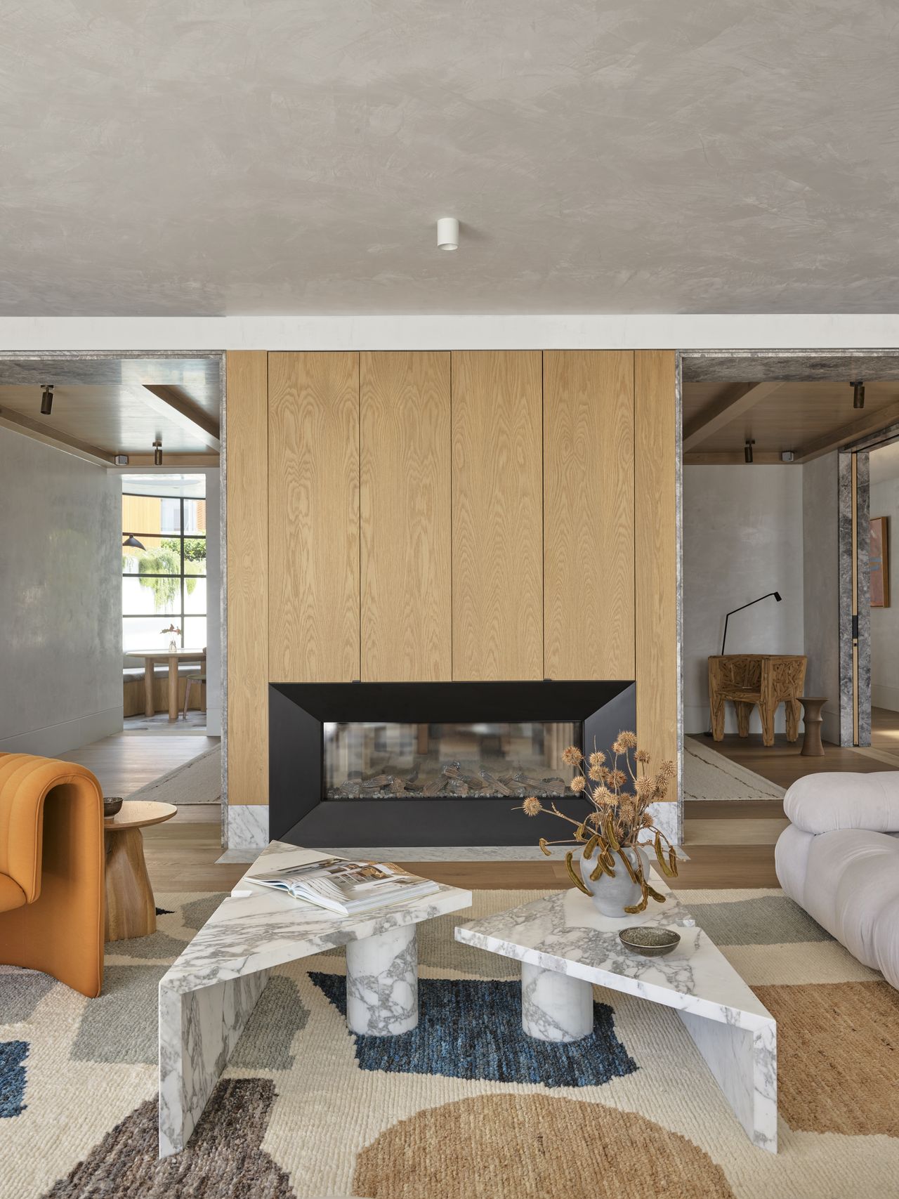 A living room with an organic-shaped coffee table in marble