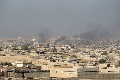 Smoke billows from buildings south of Mosul.