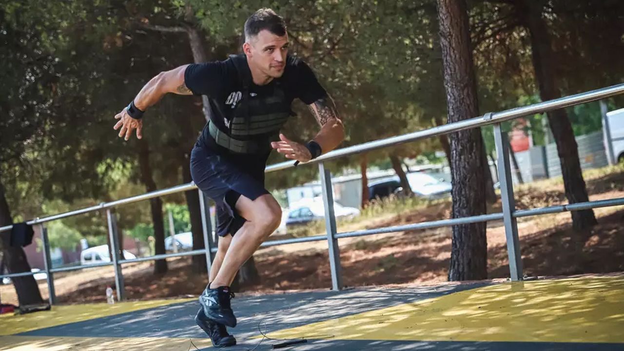 best weighted vest: Pictured here, an athletic man running up some steps outdoors wearing a weighted vest