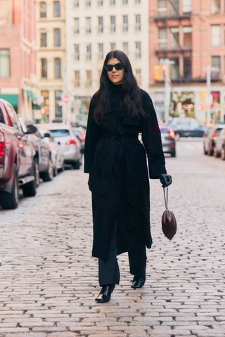 Neada protects a purely black anti-trend outfit in New York with a wool coat, a turtleneck sweater, a pants with a straight leg and Square-Tea boots.