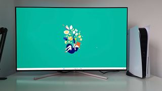 Philips Evnia 42M2N8900 with green Kiki's Delivery Service wallpaper on screen next to PS5