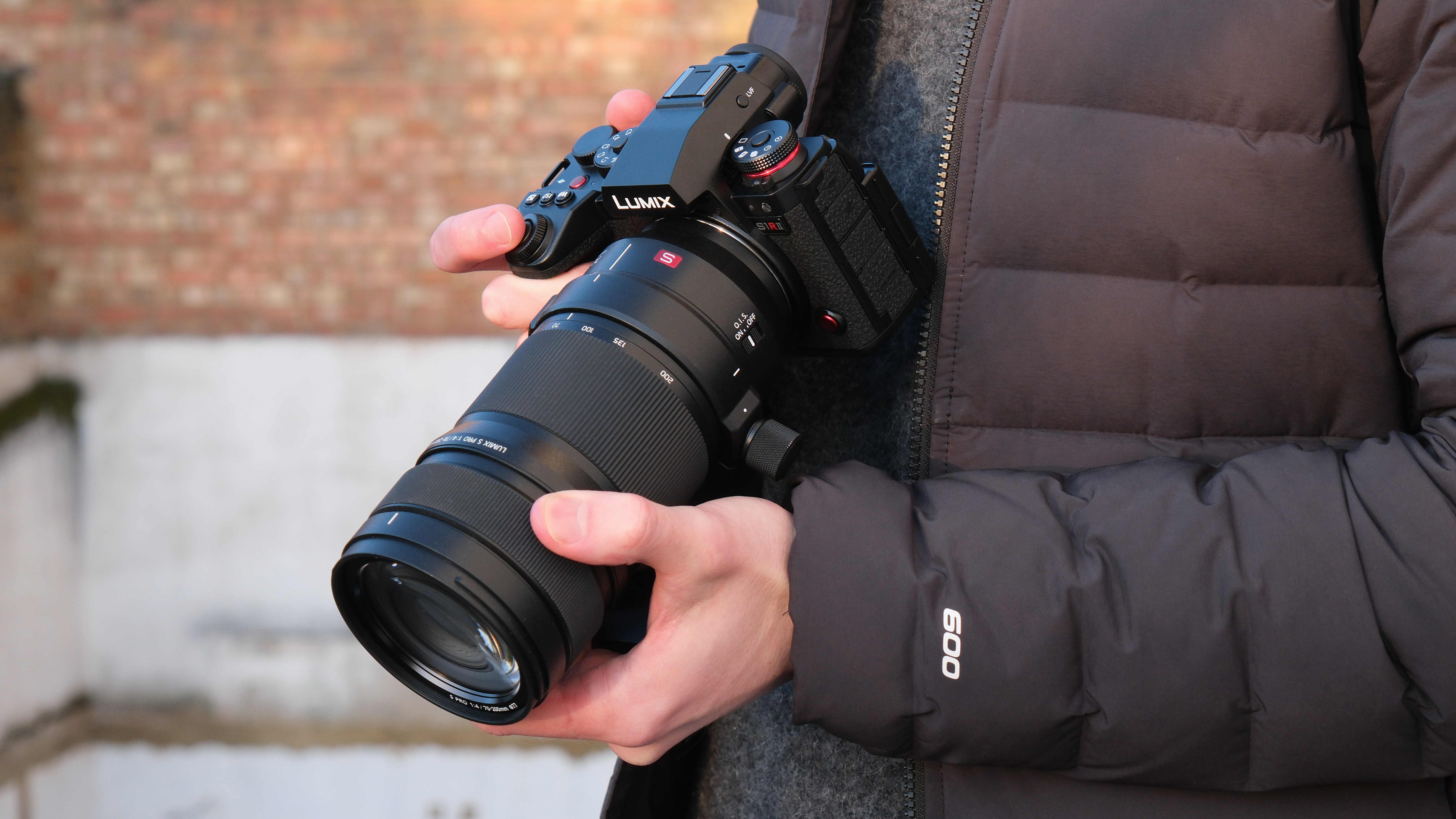 Panasonic Lumix S1R II camera with 70-200mm lens attached held in a person's hands