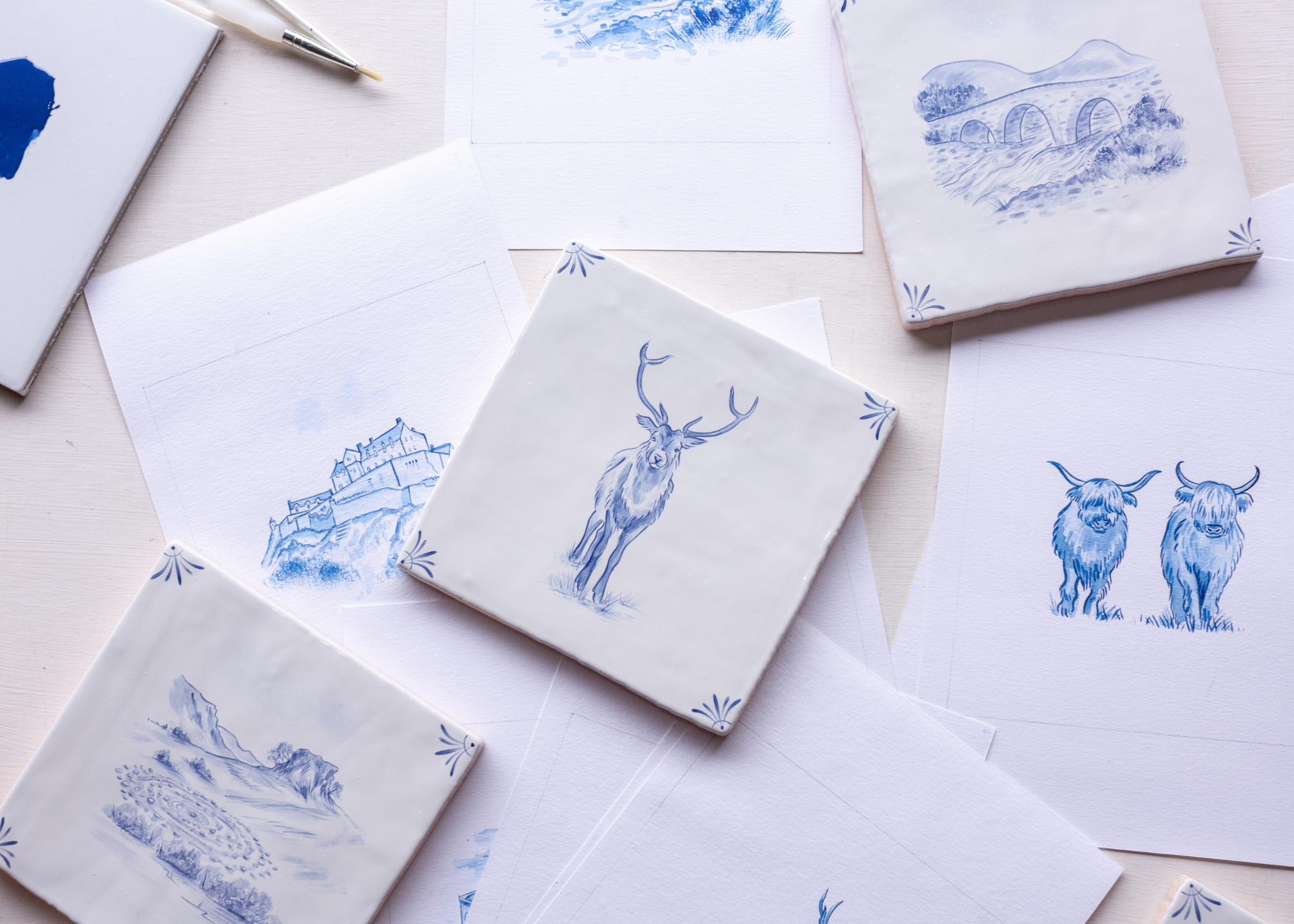 hand painted delft tiles with animals and sketches around the tiles