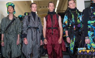 Group of male models wearing long jackets & matching trousers