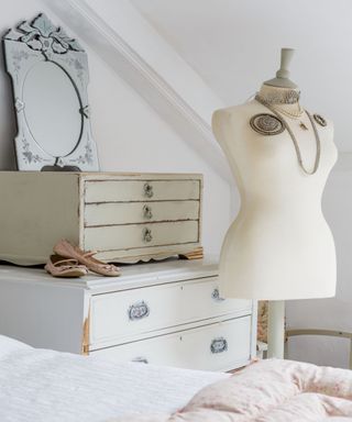 Bedroom with bed, chest of drawers and mannequin with jewelry