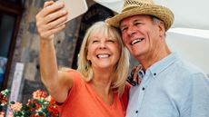 Senior couple taking a selfie at an outdoor market 