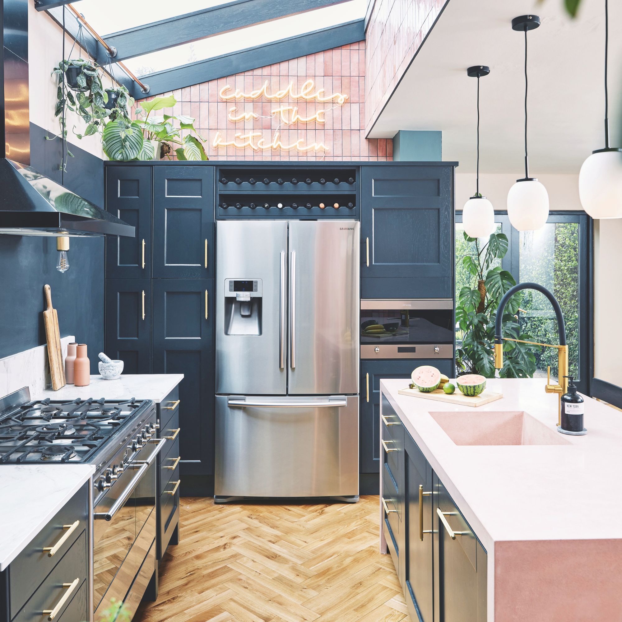 Brightly coloured kitchen with blue cabinets and a large American-style fridge-freezer in the middle