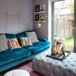 living room with grey wall and blue sofa