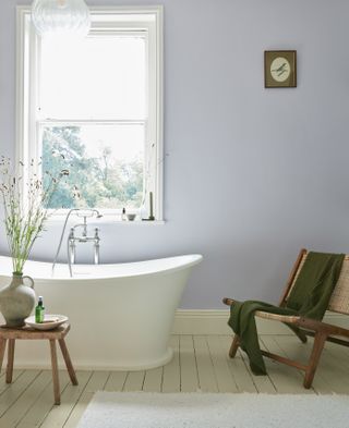 bathroom with lilac walls, white floor and freestanding roll top bath