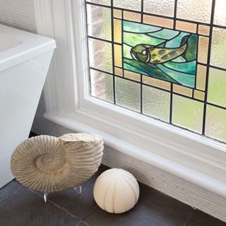 dart tiled bathroom with fish design on stained glass
