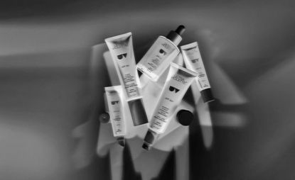 Black and white image of ultra violette sunscreens piled together 