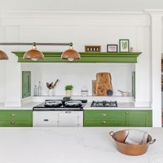 Green kitchen with white work tops and wall, with large kitchen island