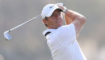 McIlroy watches his shot whilst striking an iron