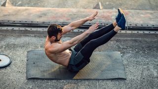 Man performing abs exercise on mat outside