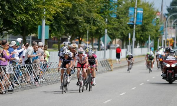 The men's break crossing the start/finish just as the women sprint for 2nd and 3rd in their race.