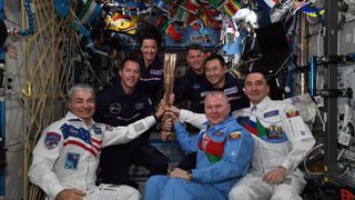 Expedition 65 astronauts celebrate the kick-off of the 2020 Paralympic Games with a torch ceremony aboard the International Space Station. 