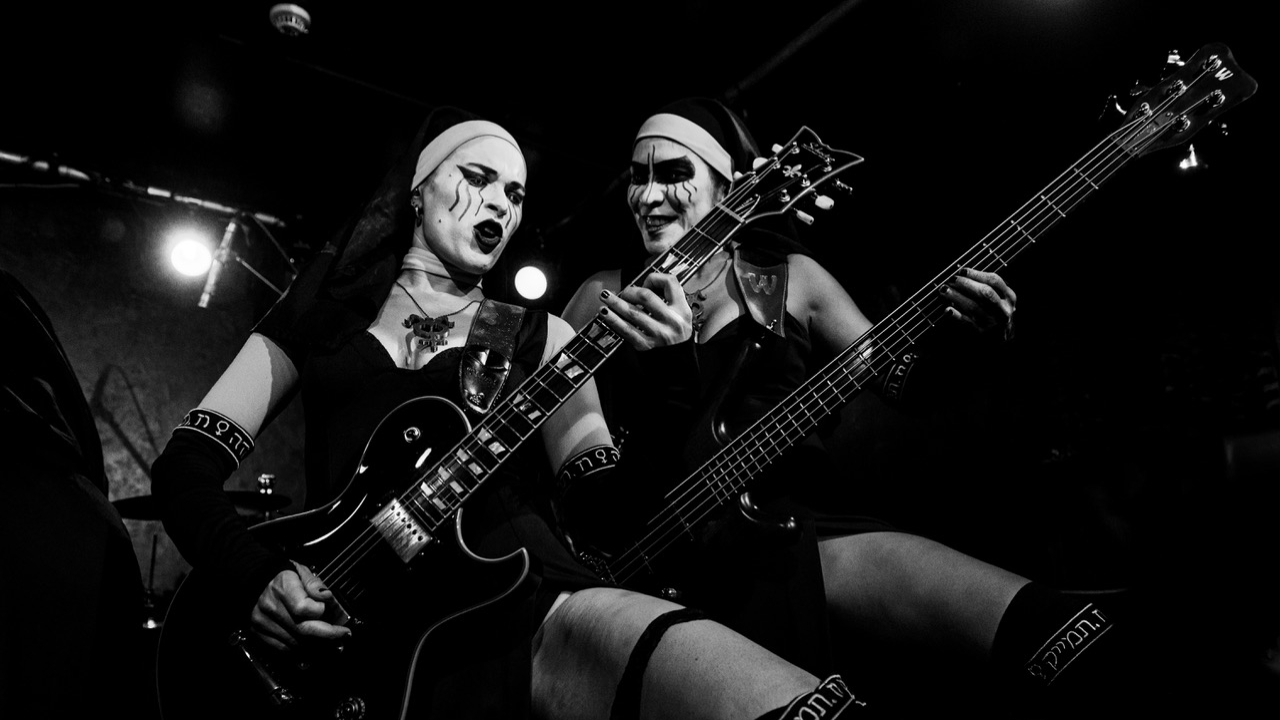 Dogma on stage holding up their guitars