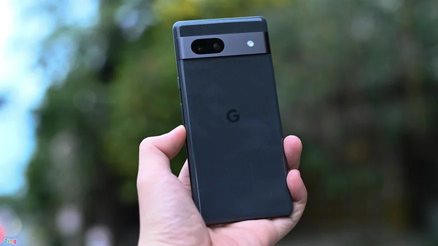 Photo of alleged Google Pixel 7a prototype in hand with a blurry background of trees