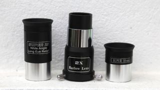 Sky-watcher explorer 130 eyepieces and barlow lens against wall