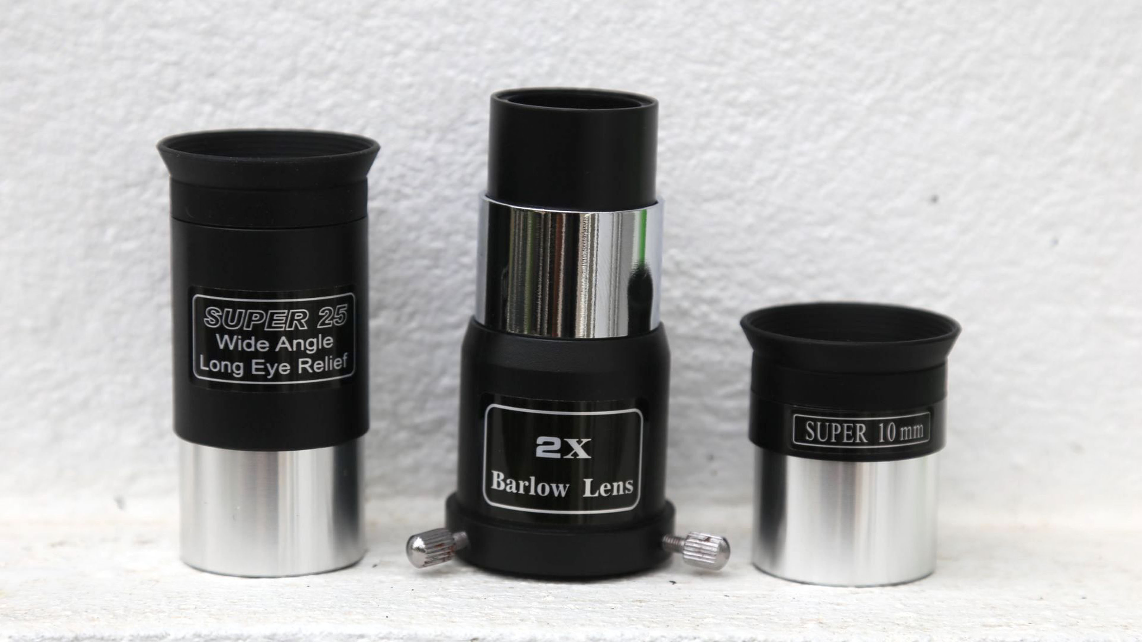 Sky-watcher explorer 130 eyepieces and barlow lens against wall