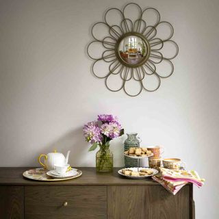 white wall with sunflower mirror and flower vase