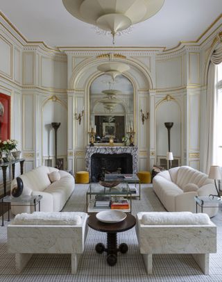 A symmetrical living room with curved sofas and trad moulding