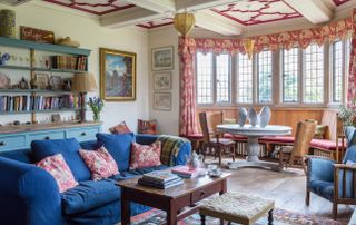living room in jacobean manor with blue sofa blue dresser and bay window