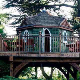 Tree house with table and chairs and a balcony