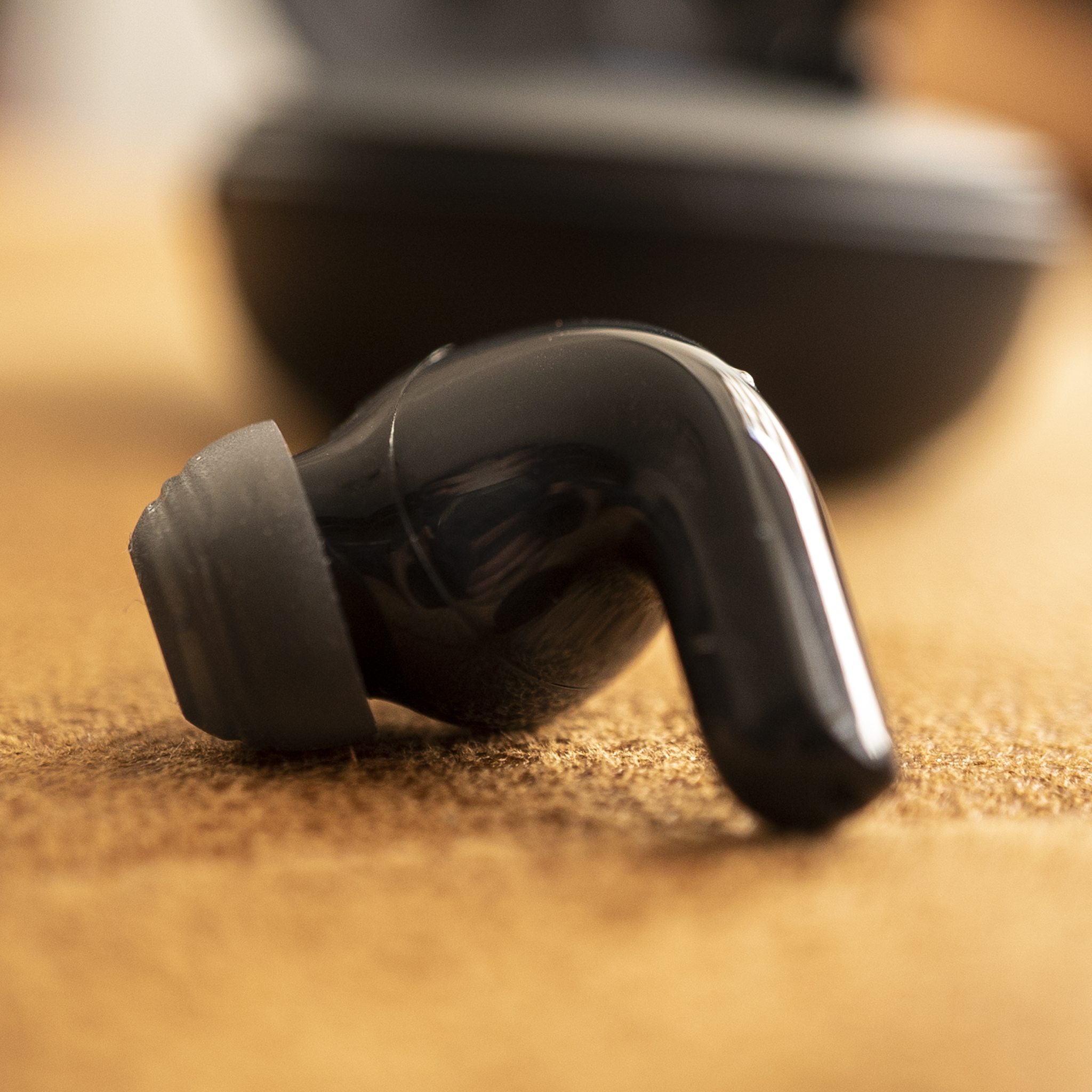 LG Tone Free T90Q earbud, on a couch