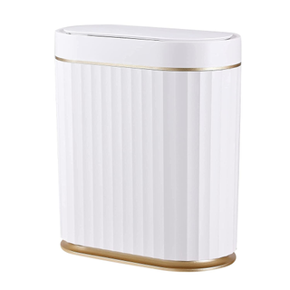 A rectangular white trash can with an automatic lid, gold accents, and a ribbed finish