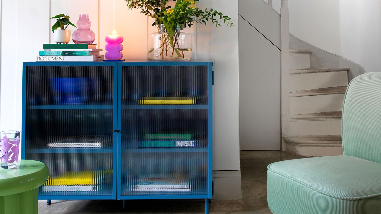 Blue glass fronted display cabinet covered with reeded window film in a living room