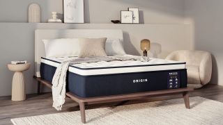 The Origin LumbarCloud Mattress on a bed frame with pillows and a throw