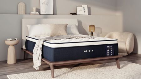 The Origin LumbarCloud Mattress on a bed frame with pillows and a throw