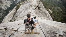 A pair of mountain climbers carefully make their way down a mountain.