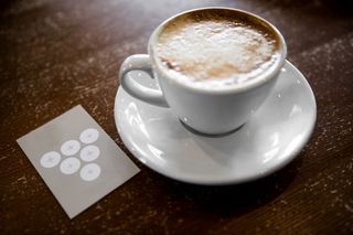 coffee shop cappuccino on a table next to a loyalty card
