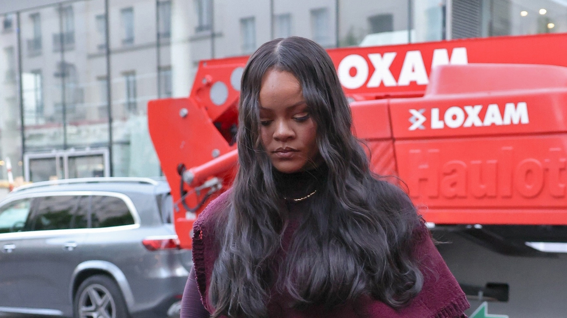 Rihanna wearing a burgundy shirt, cargo pants, and pointed-toe shoes