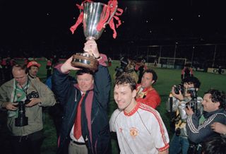 ROTTERDAM, NETHERLANDS - MAY 15: Manchester United manager Sir Alex Ferguson holds aloft the trophy as captain Bryan Robson looks on after 1991 UEFA European Cup Winners Cup Final victory against Barcelona on May 15th, 1991 in Rotterdam, Netherlands. (Photo by Simon Bruty/Allsport/Getty Images/Hulton Archive)