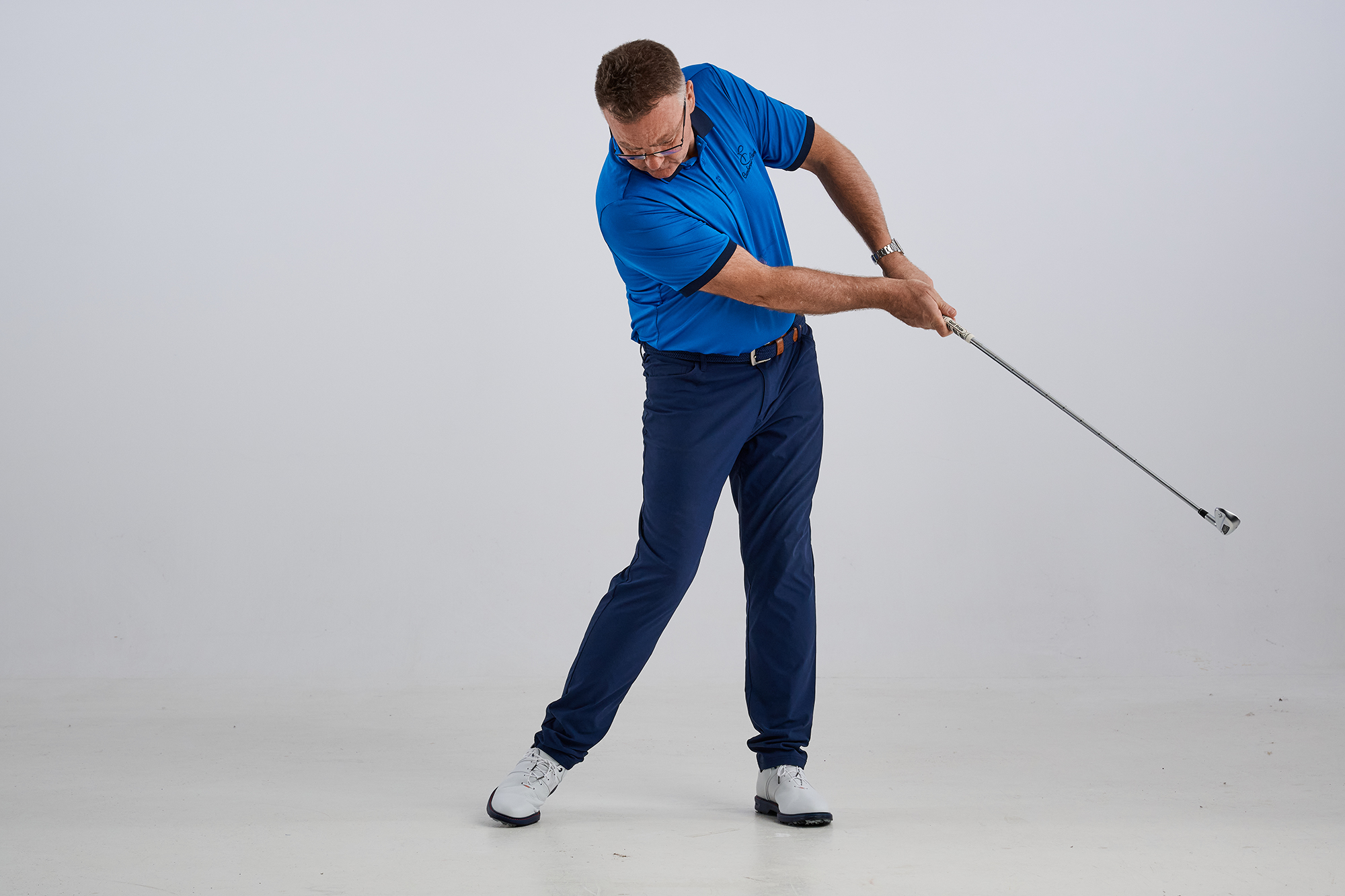 John Jacobs showcasing what a chicken wing in the golf swing is