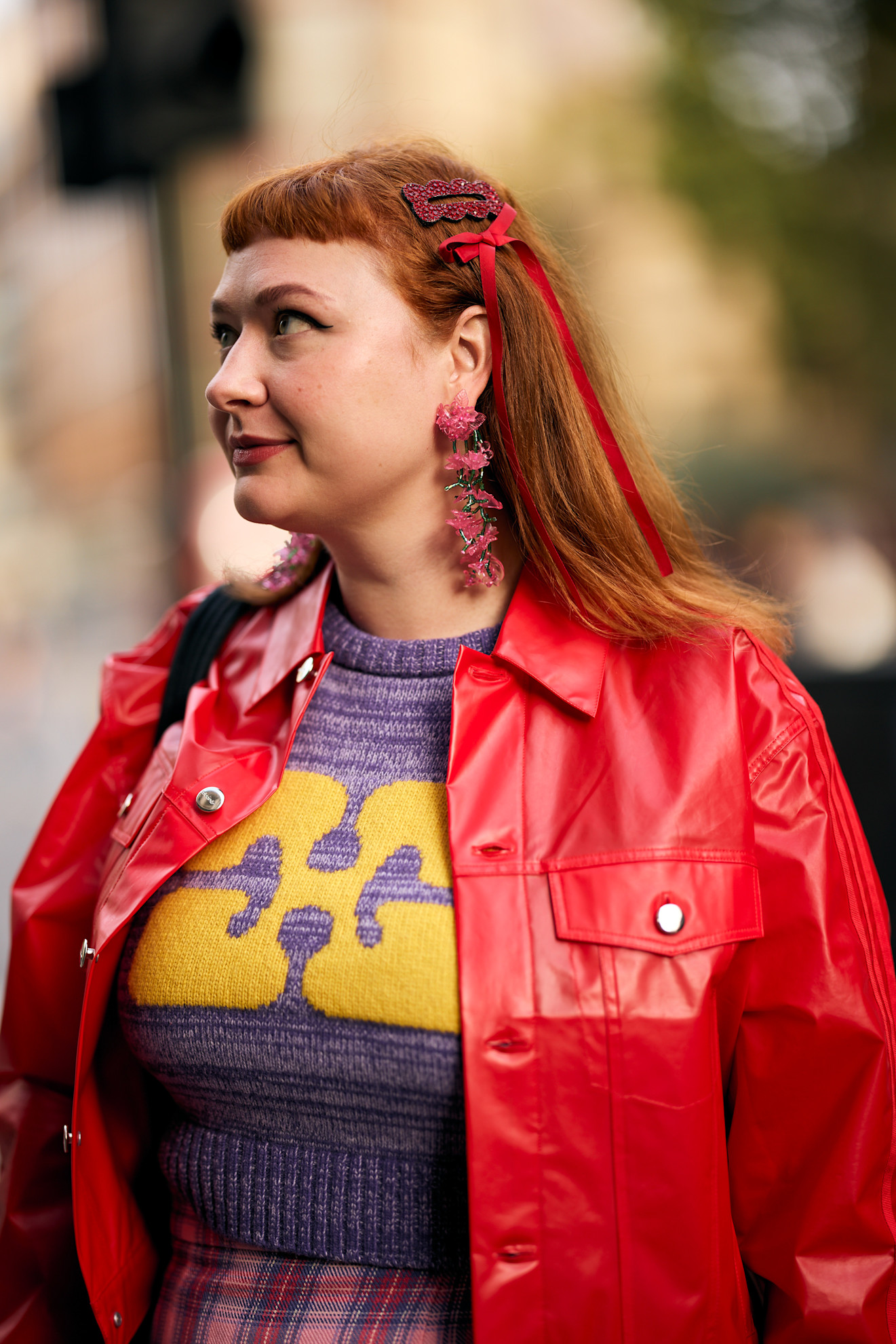 a white woman with red hair in a red jacket with bows in her hair