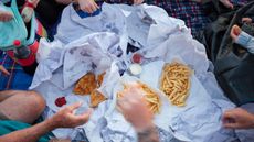 People eating fish and chips at a picnic