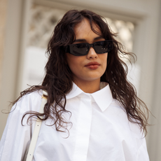 woman with wavy hair and sunglasses wearing a white shirt - best Mattifying primer