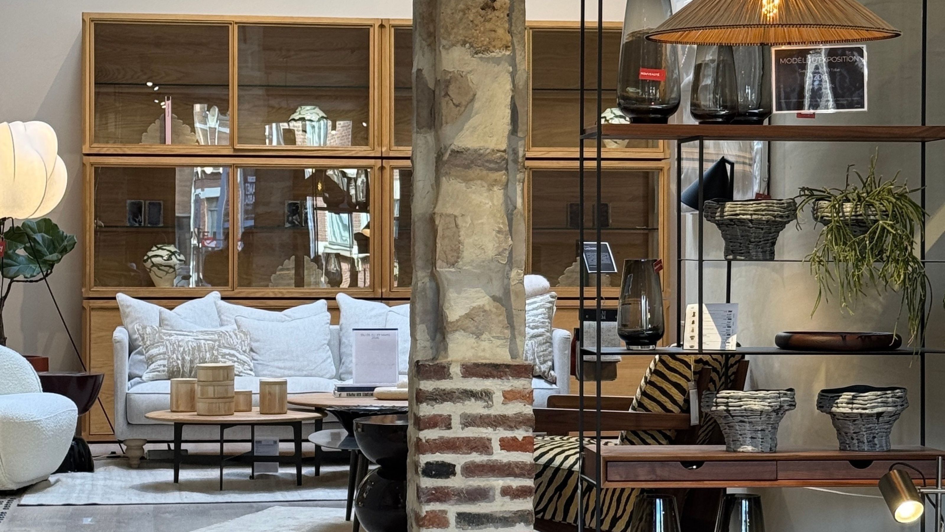La Redoute AM.PM store with sofa, shelves of homeware, floor lamp, coffee tables, and brick columns