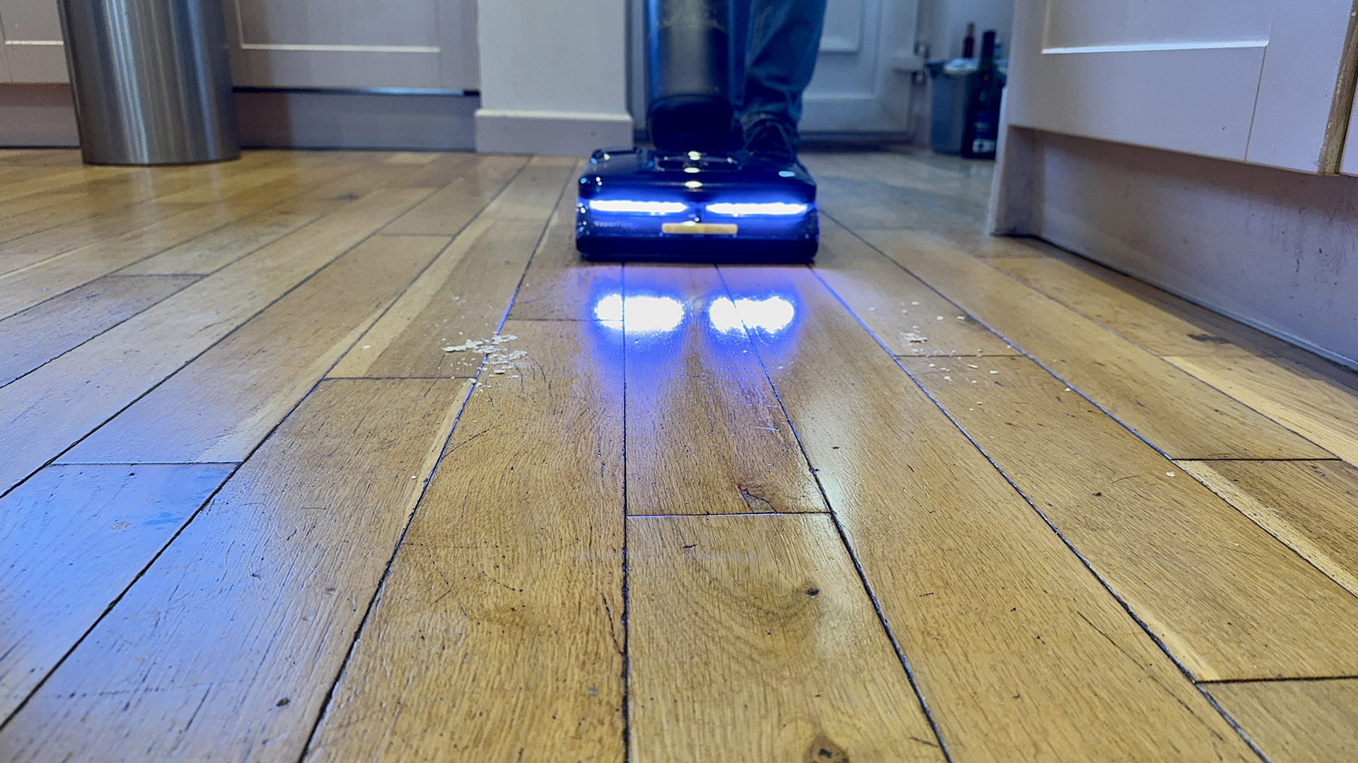 Roborock F25 Ultra clearing a mess of egg, oats, ketchup and more from an engineered wooden floor