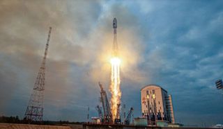 a white rocket rises into a foggy sky