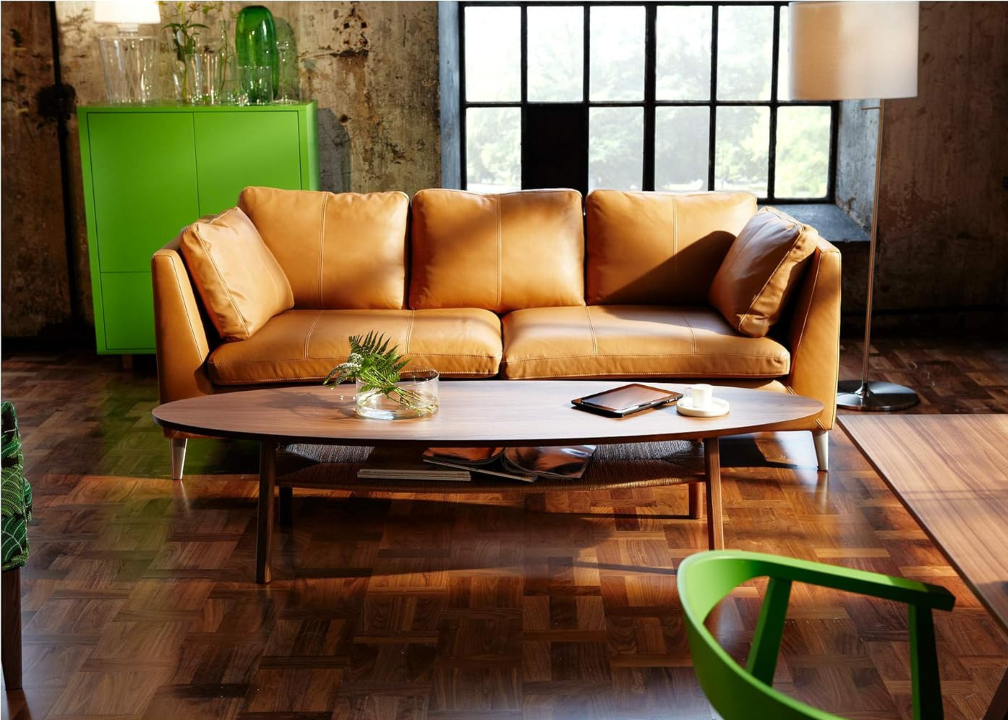 a living room with ikea stockholm coffee table with an orange leather sofa and green cabinet and chair